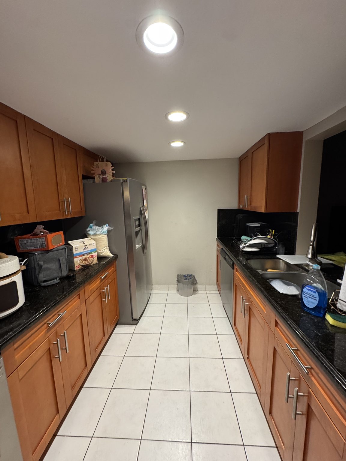 Galley kitchen — wood cabinets, granite, stainless